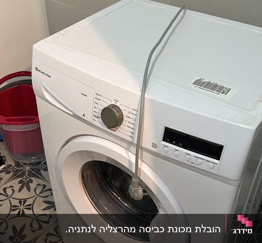 מכונת כביסה לבנה עם כפתור שליטה